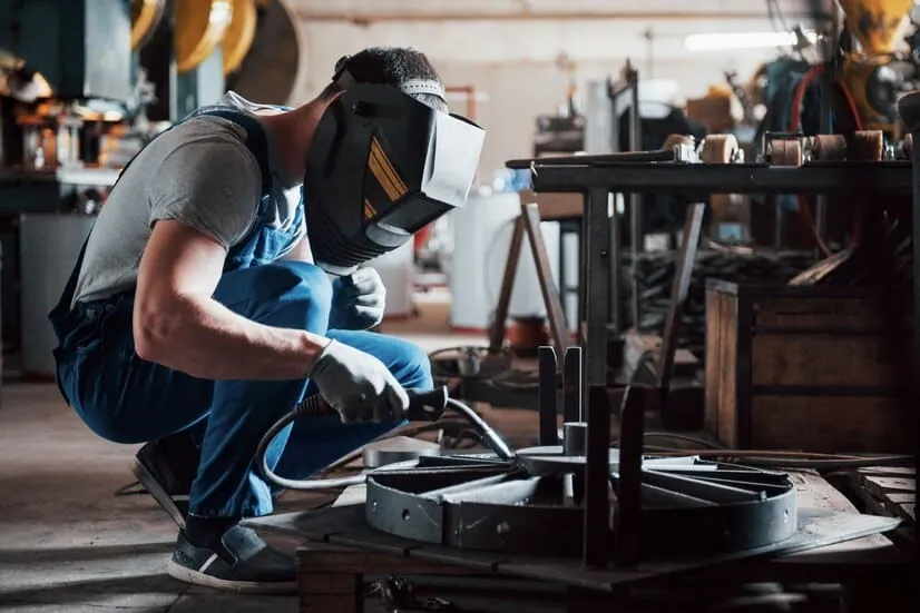 trabajador diseñando pieza metálica