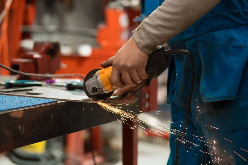 trabajador cortando con amoladora